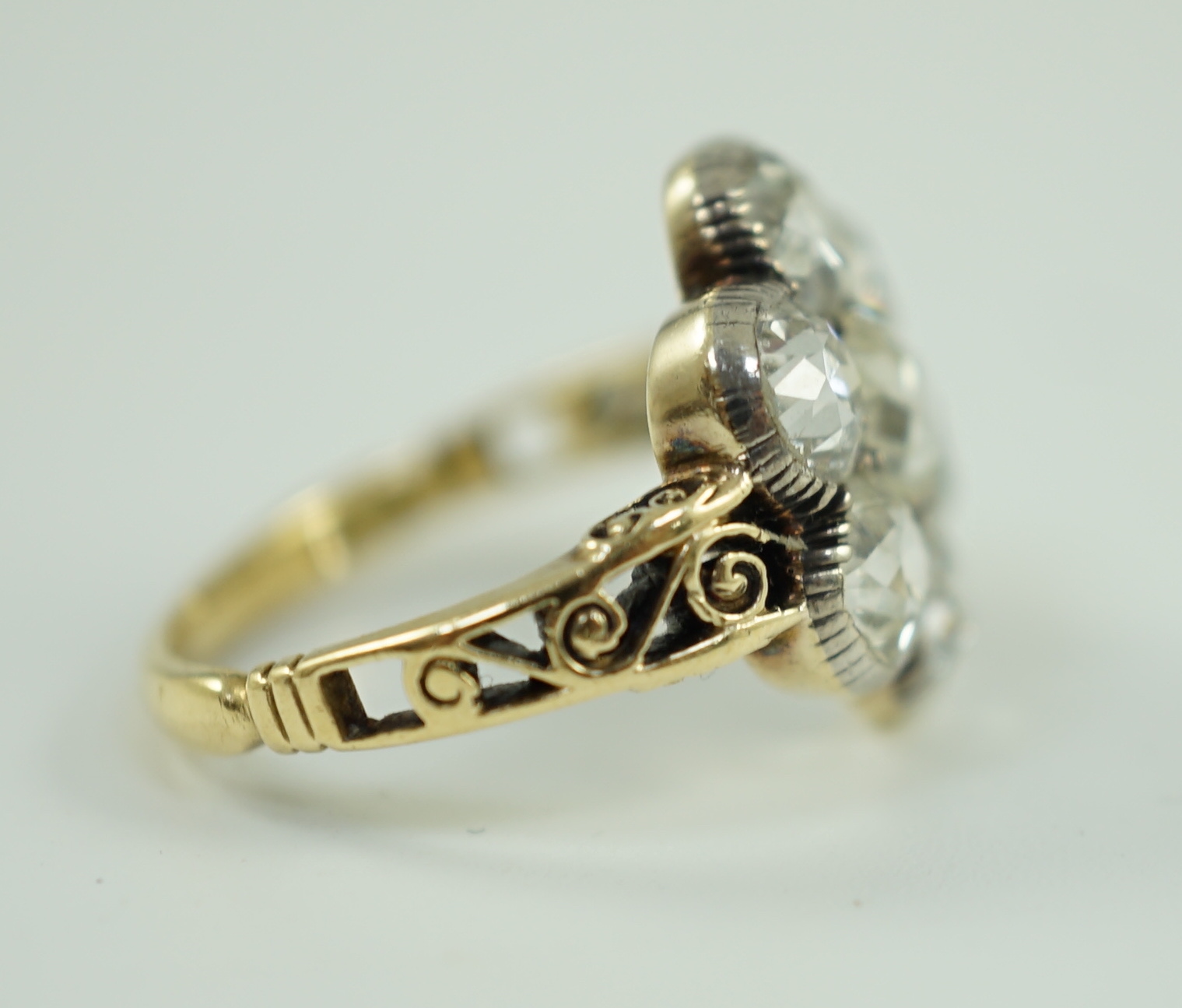 A late 19th/early 20th century gold and collet set seven stone old round cut diamond flower head cluster ring